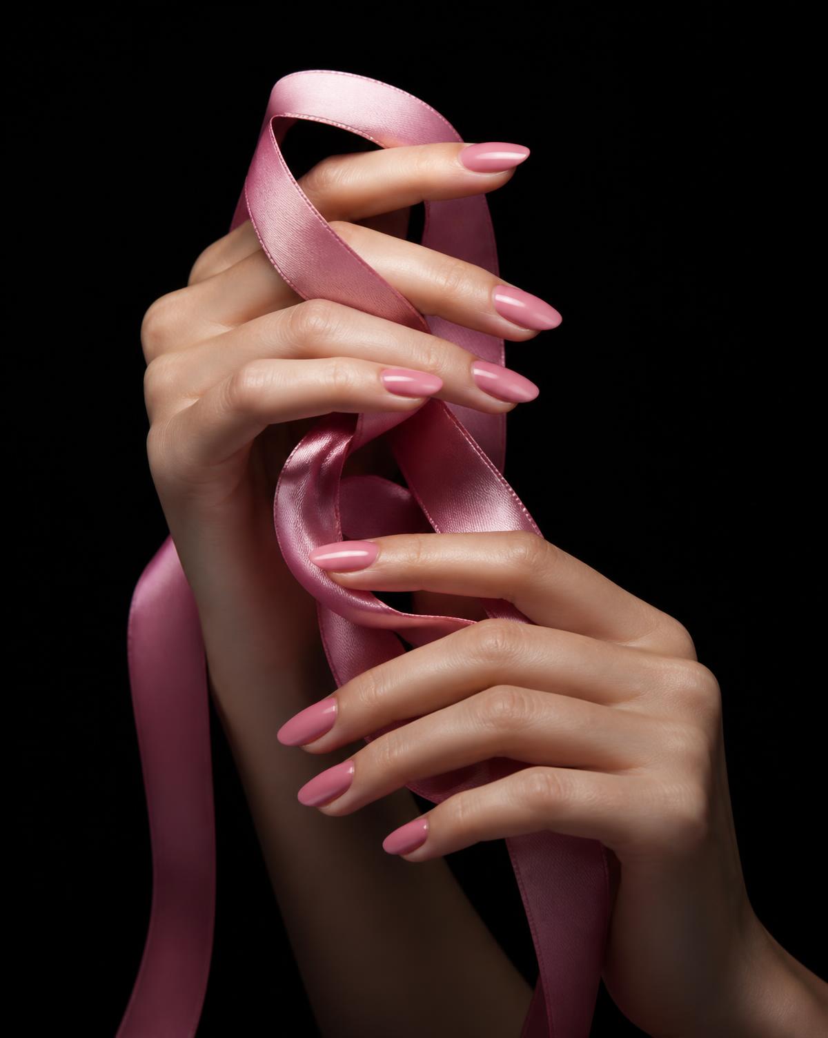 Pink manicure holding silk ribbon